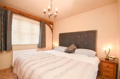 a bedroom with a large bed and a window at The Barn in Little Maplestead