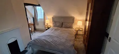 a bedroom with a large bed with two lamps at The Walnut Nook in Abbess Roding