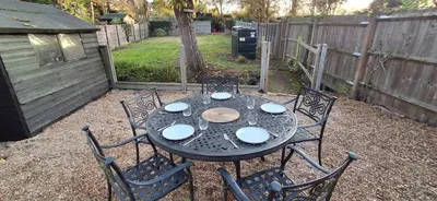 a black table with four chairs and a fence at The Walnut Nook in Abbess Roding