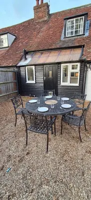 a black table and chairs in front of a house at The Walnut Nook in Abbess Roding