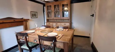 a dining room table with chairs and a wooden table and chairsktop at The Walnut Nook in Abbess Roding