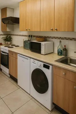 a kitchen with a washing machine and a microwave at The Little Nest in Colchester in Colchester
