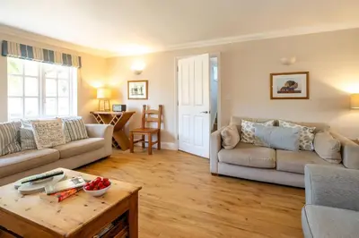a living room with a couch and a table at 7 Sanctuary Court - sleeps 12 - Thorpeness - Aldeburgh Coastal Cottages - Close to the Beach, Golf and the Country Club in Thorpeness
