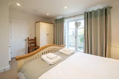 a bedroom with a large bed with towels on it at 7 Sanctuary Court - sleeps 12 - Thorpeness - Aldeburgh Coastal Cottages - Close to the Beach, Golf and the Country Club in Thorpeness