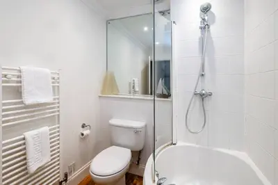 a white bathroom with a toilet and a shower at 7 Sanctuary Court - sleeps 12 - Thorpeness - Aldeburgh Coastal Cottages - Close to the Beach, Golf and the Country Club in Thorpeness