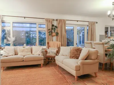 a living room with two couches and a table at Berkley Cottage in Colchester