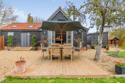 a wooden deck with a table and chairs in front of a house at 1 Bed in Dickleburgh oc-m33974 in Dickleburgh