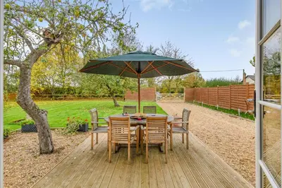a table and chairs with an umbrella on a deck at 1 Bed in Dickleburgh oc-m33974 in Dickleburgh