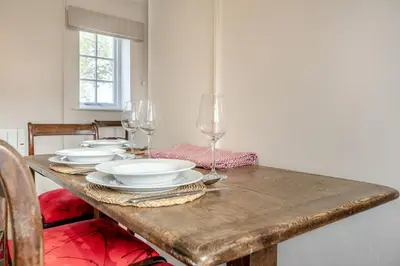a wooden table with plates and wine glasses on it at 2 Bed in Bressingham oc-f33646 in Bressingham