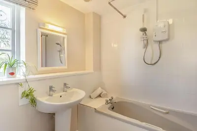 a white bathroom with a sink and a bath tub at 2 Bed in Bressingham oc-f33646 in Bressingham