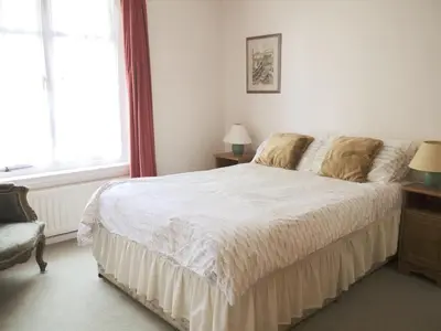 a bedroom with a large white bed and a window at Period Family House by the Beach in Walton-on-the-Naze
