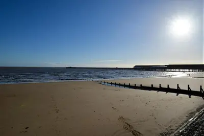a beach with a pier and the ocean at Period Family House by the Beach in Walton-on-the-Naze
