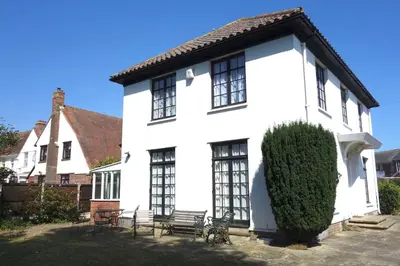 a white house with a bench in front of it at Period Family House by the Beach in Walton-on-the-Naze