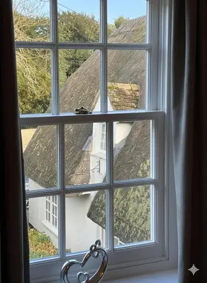 a window with a view of a roof at Charming Willow Cottage in historic Grantchester in Barton
