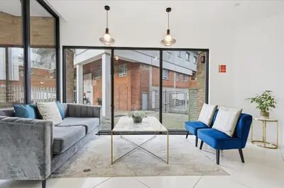 a living room with a couch and two chairs and a table at Heart of Brentwood - 1 Bed - Underground Parking - Fast Wifi in Brentwood