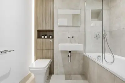 a bathroom with a toilet and a sink and a shower at Heart of Brentwood - 1 Bed - Underground Parking - Fast Wifi in Brentwood