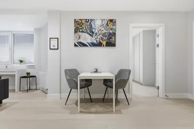 a dining room with a table and chairs and a painting at Heart of Brentwood - 1 Bed - Underground Parking - Fast Wifi in Brentwood