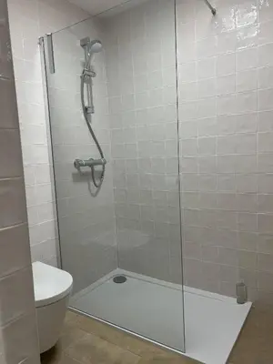 a shower with a glass door and a toilet at Stylish One Bedroom Apartment in Central Potton in Potton