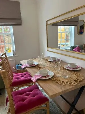 a wooden table with wine glasses and a mirror at Stylish One Bedroom Apartment in Central Potton in Potton