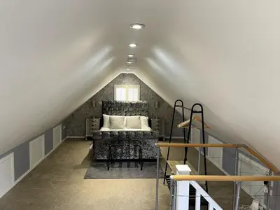 a attic room with a bed and a window at Greenfinch Lodge