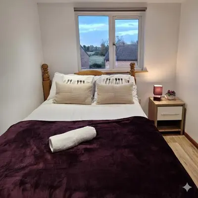 a bedroom with a large bed with a window at Modern 4BR Cambridge House with Parking for 9 guests in Cambridge