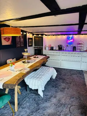 a kitchen with a long wooden table with a bench at Outlook farm cabin firepit in Hertford