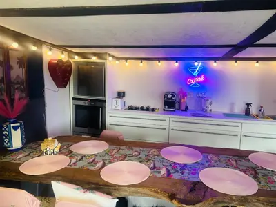 a kitchen with a table and a kitchen with purple lights at Outlook farm cabin firepit in Hertford