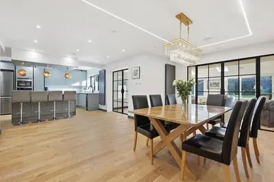 a dining room and kitchen with a wooden table and chairs at Four Bed House by Brookland Stays Serviced Accommodation Short Lets Brentwood with Free WiFi
