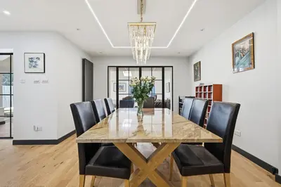 a dining room with a wooden table and black chairs at Four Bed House by Brookland Stays Serviced Accommodation Short Lets Brentwood with Free WiFi
