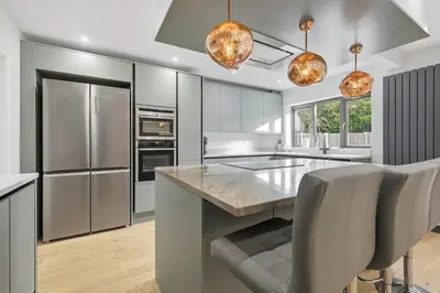 a kitchen with stainless steel appliances and a large island at Four Bed House by Brookland Stays Serviced Accommodation Short Lets Brentwood with Free WiFi