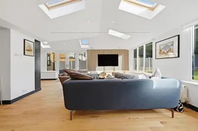 a living room with a couch and a tv at Four Bed House by Brookland Stays Serviced Accommodation Short Lets Brentwood with Free WiFi