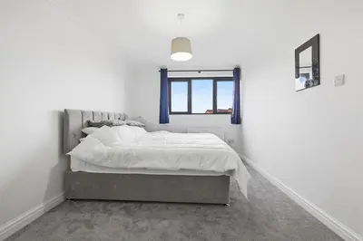 a bedroom with a bed and a window at Four Bed House by Brookland Stays Serviced Accommodation Short Lets Brentwood with Free WiFi