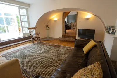 a living room with a couch and a tv at The Manor Dairy in Sandy