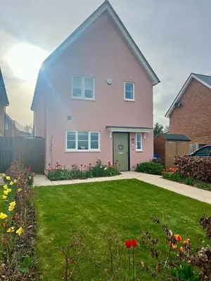a pink house with a green yard at The Pink House in Lavenham