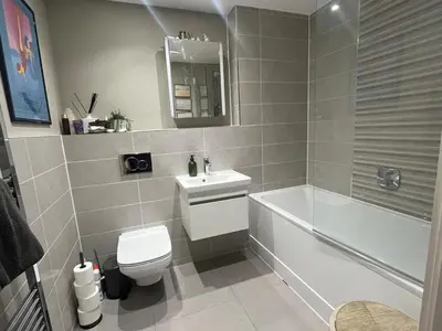 a bathroom with a toilet and a tub and a sink at The Pink House in Lavenham