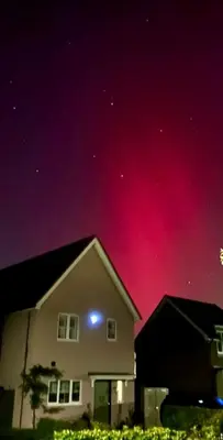 a house with a blue light in the night sky at The Pink House in Lavenham