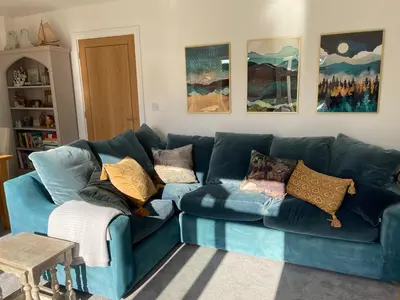 a blue couch in a living room with pillows on it at The Pink House in Lavenham