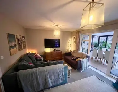 a living room with two couches and a tv at The Pink House in Lavenham