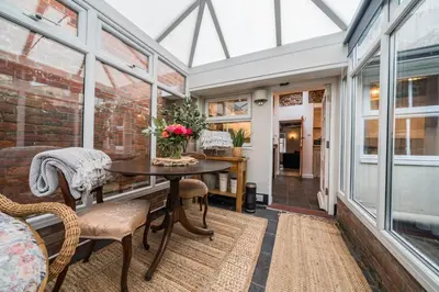 a conservatory room with a table and chairs and windows at Bridewell Lane, Bury St Edmunds, Suffolk in Bury Saint Edmunds