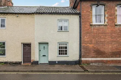 a brick house with a blue door and windows at Bridewell Lane, Bury St Edmunds, Suffolk in Bury Saint Edmunds