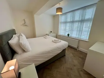 a small bedroom with a bed and a window at 3 The Royal Serviced Apartments, Harwich -Ground Floor-Parking -Wifi in Parkeston
