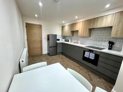 a kitchen with a white table and a refrigerator at 3 The Royal Serviced Apartments, Harwich -Ground Floor-Parking -Wifi in Parkeston