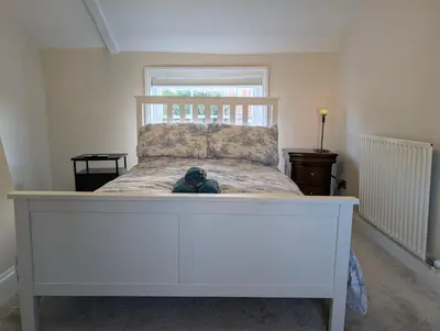 a large white bed with a stuffed animal on it at Central Grade 2 listed cottage in Attleborough