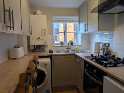 a kitchen with a washing machine and a sink at Central Grade 2 listed cottage in Attleborough
