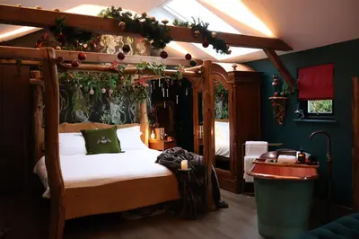 a bedroom with a canopy bed with christmas decorations at Hollow Heath in Layer de la Haye
