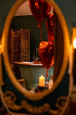 a bathroom mirror with a sink and a candle at Hollow Heath in Layer de la Haye