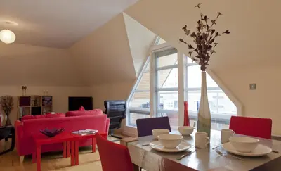 a dining room with a table and red chairs at Toothbrush Apartments - Central Ipswich St Peters St in Ipswich