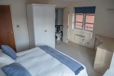 a bedroom with a bed with a blue blanket on it at Toothbrush Apartments - Central Ipswich St Peters St in Ipswich