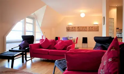 a living room with a red couch and chairs at Toothbrush Apartments - Central Ipswich St Peters St in Ipswich