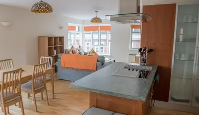 a kitchen and living room with a table and a couch at Toothbrush Apartments - Central Ipswich St Peters St in Ipswich